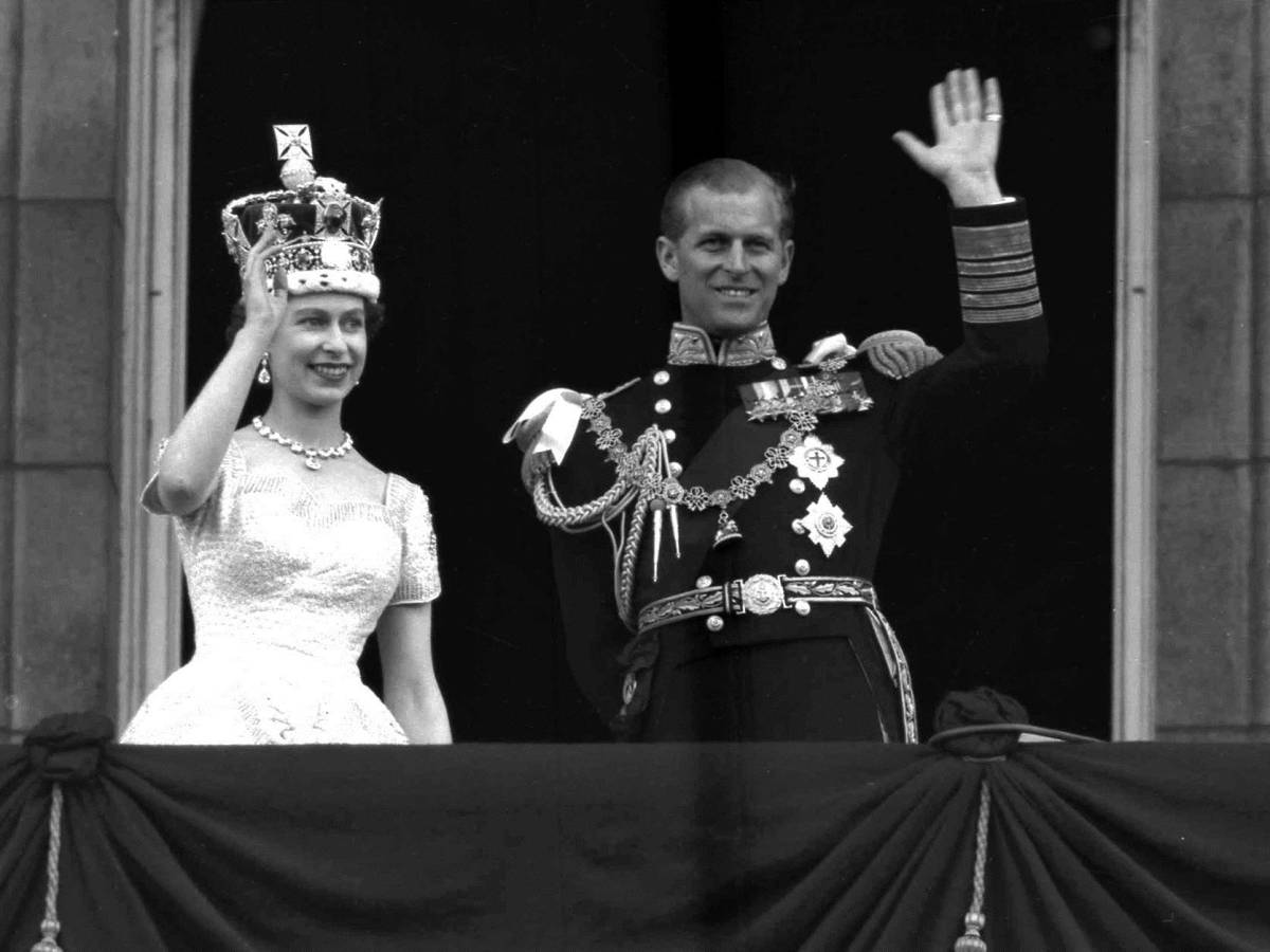 En esta imagen del 2 de junio de 1953, la reina Isabel II y su esposo Felipe saludan desde el balcón de Buckingham Palace luego de su histórica coronación en la abadía de Westminster (AP Photo/Leslie Priest, File)