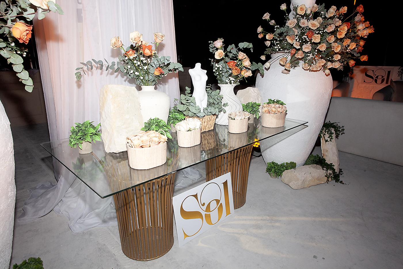 Hermosos arreglos en diferentes formas y tamaños con rosas, follaje y ramas de eucalipto adornaron el salón dispuesto para el cóctel.