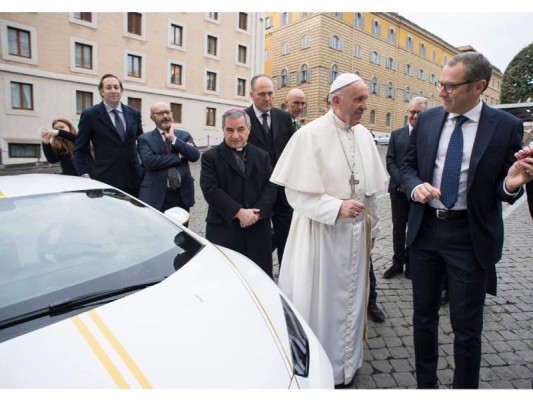 This handout photo taken on November 15, 2017 at the Vatican and released by the Vatican press office, Osservatore Romano shows Pope Francis speaking with Lambhorgini CEO Stefano Domenicali (R) after receiving a Lamborghini Huracan as a gift from the Italian car company. / AFP PHOTO / OSSERVATORE ROMANO / Handout