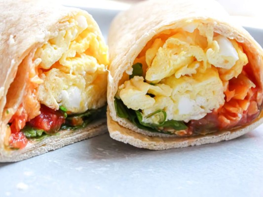 BURRITOS CON HUEVO Y AGUACATE<br/><br/>INGREDIENTES<br/>1 cucharada de aceite de oliva / 1/4 taza de salsa de tomate natural / 6 huevos/ 1 chile jalapeño sin semillas cortado en cubitos / 1/4 cebolla morada finamente picada / 4 tortillas de harina integral o al gusto / 2 aguacates en rodajas / 1 diente de ajo picado.<br/><br/>PREPARACIÓN<br/>1/ Bate los huevos con una cucharada de leche para hacerlos más ligeros y esponjosos. Reserva. 2/ Calienta el aceite a fuego medio en una sartén mediana. Añade el chile, ajo y la cebolla y saltea un par de minutos hasta que estén tiernos. 3/ Bate los huevos una vez más y vierte en la sartén con la cebolla. Mueve para obtener unos huevos revueltos y retira del calor rápidamente para que no se sequen. 4/ Reparte los huevos en las tortillas. 5/ Añade el aguacate y jalapeño, envuelve y sirve caliente. 6/ Si deseas variar la receta puedes añadir jamón de pavo picado o bacon.<br/>