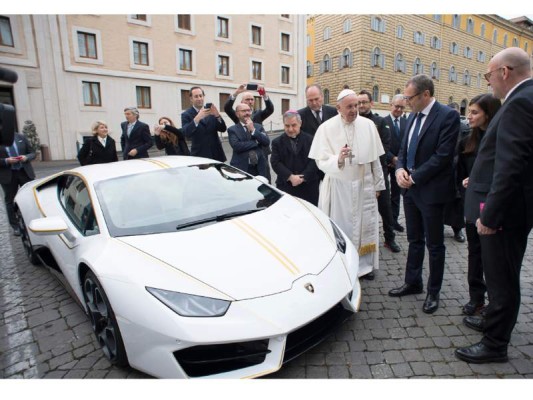 This handout photo taken on November 15, 2017 at the Vatican and released by the Vatican press office, Osservatore Romano shows Pope Francis speaking with Lambhorgini CEO Stefano Domenicali (2ndR) after receiving a Lamborghini Huracan as a gift from the Italian car company. / AFP PHOTO / OSSERVATORE ROMANO / Handout This handout photo taken on November 15, 2017 at the Vatican and released by the Vatican press office, Osservatore Romano shows Pope Francis speaking with Lambhorgini CEO Stefano Domenicali (2ndR) after receiving a Lamborghini Huracan as a gift from the Italian car company. / AFP PHOTO / OSSERVATORE ROMANO / Handout