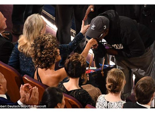 El sorprendido visitante besa la mano de Halley Berry durante su recorrido sorpresa en los Oscar