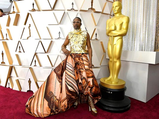 El actor Billy Porter llego con un diseño denominado Cupola elaborado por el inglés Giles Deacon, en parte superior es un top de plumas doradas sin mangas y con cuello alto, la clave está en una enorme falda abullonada hecha a partir de un tejido estampado en tonos anaranjados con motivos clásicos y heráldicos, como un inmenso pañuelo clásico transformado en prenda con autonomía propia.