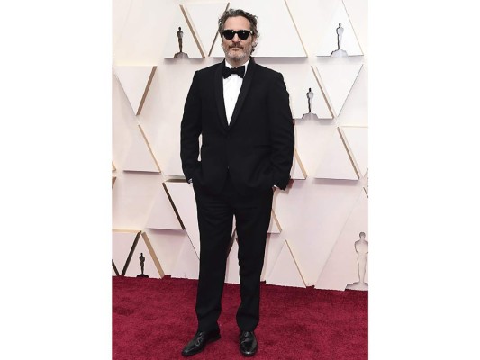 Joaquin Phoenix vestido con un esmoquin clásico de solapa redondeada de Stella McCartney y sus inseparables gafas negras de Garrett Leight