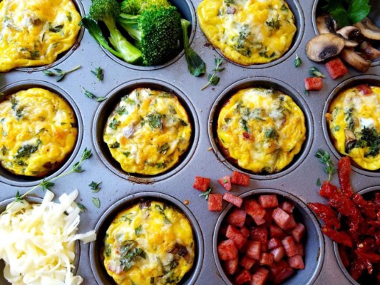 MUFFINS DE HUEVO Y CHAMPIÑONES<br/><br/>INGREDIENTES<br/>Tres cucharadas de aceite para cocinar los champiñones /1 taza de espinacas frescas / Flores de brócoli picadas/ Una taza de tomate finamente picado/ 4 huevos /1 taza de queso mozzarella rallado/ 1 taza de champiñones en rodajas/ Sal y pimienta al gusto / Dos cucharadas de crema de leche (opcional)<br/><br/>PREPARACIÓN<br/>1/ Precalienta el horno a 350 grados F. 2/ Saltea los champiñones en aceite caliente por 5 minutos. 3/ En un tazón mezcla los champiñones con las espinacas, brócoli, tomate, los huevos batidos y si lo deseas, la crema. 3/Engrasa un molde para muffins y reparte la mezcla en partes iguales. Hornea por aproximadamente 20 minutos. Decora con queso mozarella o cheddar rallado.<br/>