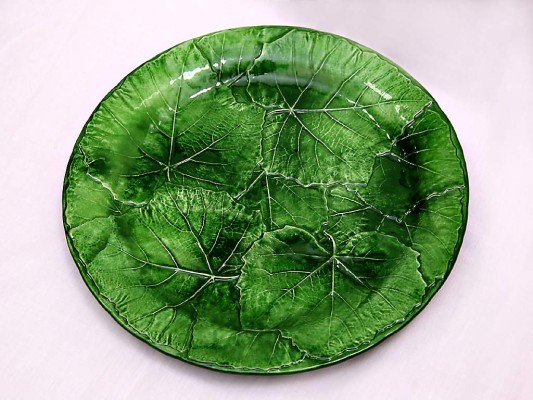 Piezas de servir en cerámica con diseño de hojas con una cubierta de glaseado en tono verde.