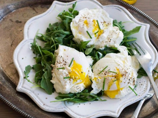 HUEVOS POCHADOS CON ESPINACA<br/><br/>INGREDIENTES <br/>1½ libras de hojas de espinaca bebé/ 3 cucharadas de aceite de oliva / 6 dientes de ajo finamente picados/ 2 cucharaditas de sal / ¾ cucharadita de pimienta / 1 limón/ 4 huevos <br/><br/>PREPARACIÓN <br/>1/ En una sartén, saltea el ajo con el aceite de oliva por un minuto a fuego bajo. Evita que se quemen. 2/ Agrega la espinaca, sal y pimienta, remueve y tapa. Cocina por dos minutos. 3/Agrega el zumo de limón y rectifica la sal y pimienta. Reserva. 4/ Para hacer los huevos, calienta a fuego medio una ollita con agua y un chorrito de vinagre blanco y deja hervir. Abre un huevo y colócalo en una tacita; luego, con una cuchara o espátula, haz un pequeño remolino en el agua hirviendo y echa el huevo en el agua hasta que cuaje (por aproximadamente dos minutos). La clara debe quedar dura y la yema blanda. 5/ Repite el proceso con cada huevo. 6/ Para el montaje, reparte la espinaca en cuatro platos y coloca encima un huevo. Salpimenta o añade chile en hojuelas.<br/>