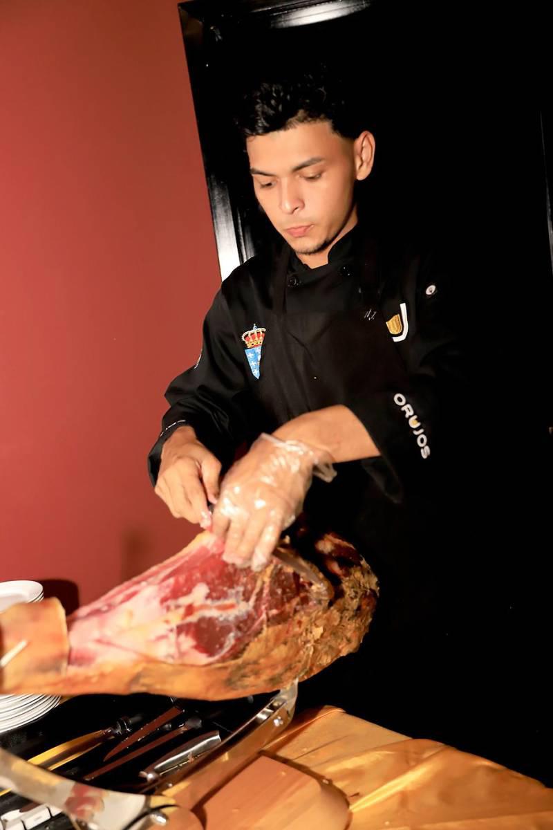 Chef de Orujos cortando con precisión una pieza de jamón ibérico. Chef de Orujos cortando con precisión una pieza de jamón ibérico.