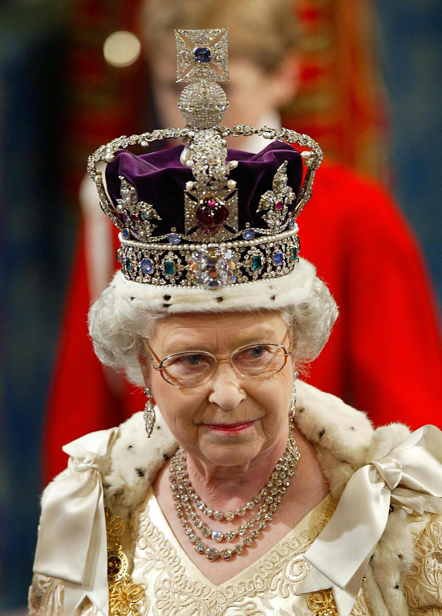 $!En esta imagen de 2002, la reina Isabel II luce la corona imperial durante su discurso de apertura en el parlamento en Londres (Photo by Adrian DENNIS / POOL / AFP)