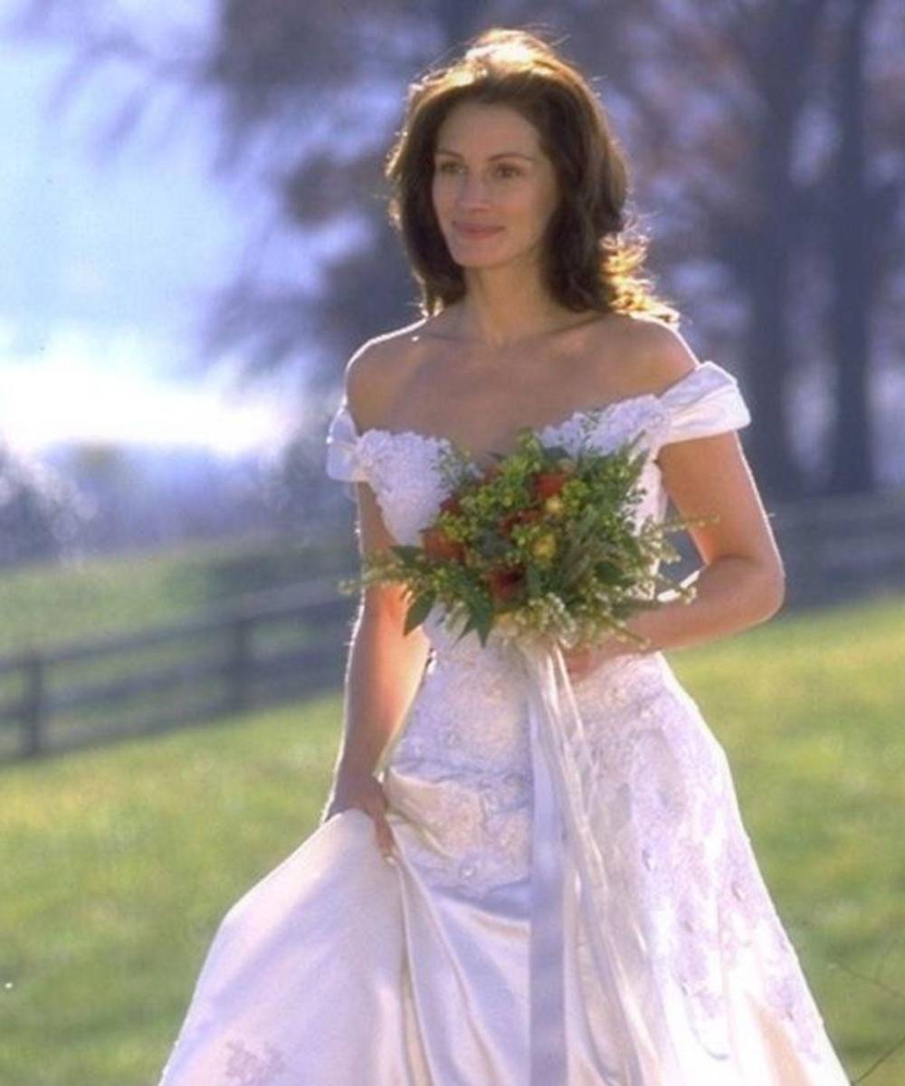 Novia a la fugaEn 1999, Julia Roberts y Richard Gere protagonizaron una de las bodas más bonitas e inolvidables del cine. El vestido que utilizó Julia en su personaje de Maggie era de un tono blanco perlado brillante de hombros descubiertos, pero con mangas ligeramente cortas que rodeaban sus brazos un poco más debajo de sus hombros.