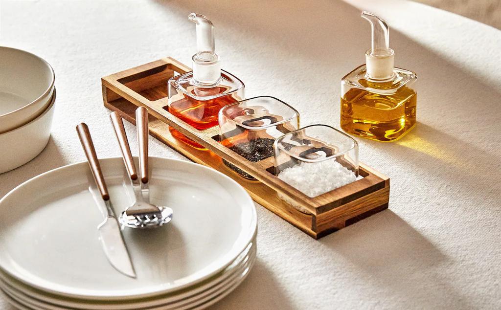<b>Cocina</b>Set de cuatro piezas para aliño que incluye aceitera, vinagrera, salero y pimientero. Tiene soporte de madera y tapón antideslizante.