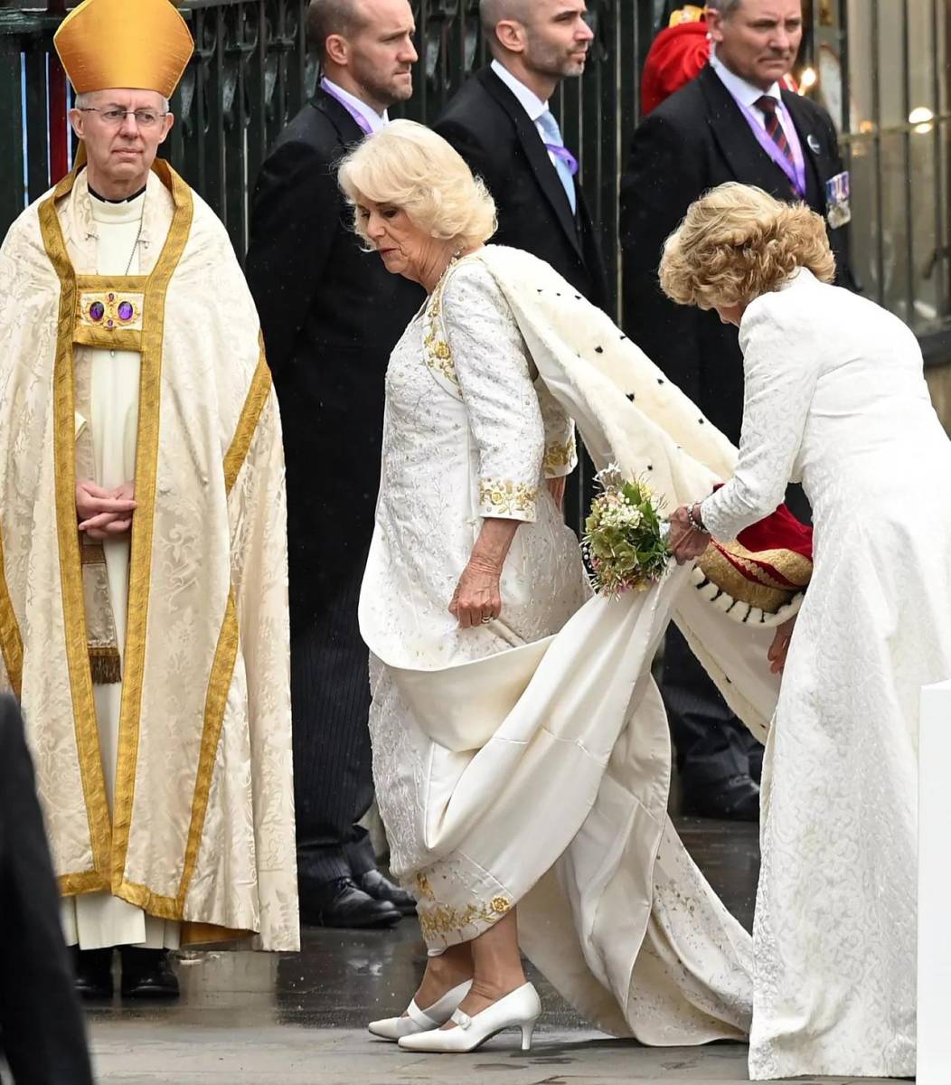 Su manto de herencia era de terciopelo morado oscuro, complementando el manto de heredad de su esposo del mismo tono. La túnica fue diseñada y bordada a mano con delicadeza por la Real Escuela de Costura, de la que la reina Camila es mecenas.