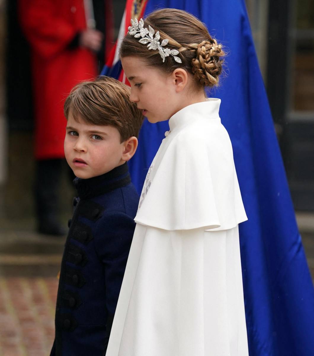 La Princesa Charlotte de ocho años, está resplandeciente con su vestido y capa de crepé de seda de color marfil de Alexander McQueebn cuyos bordados con motivos de rosas, cardos, narcisos y tréboles simbolizan las cuatro naciones que conforman Reino Unido.