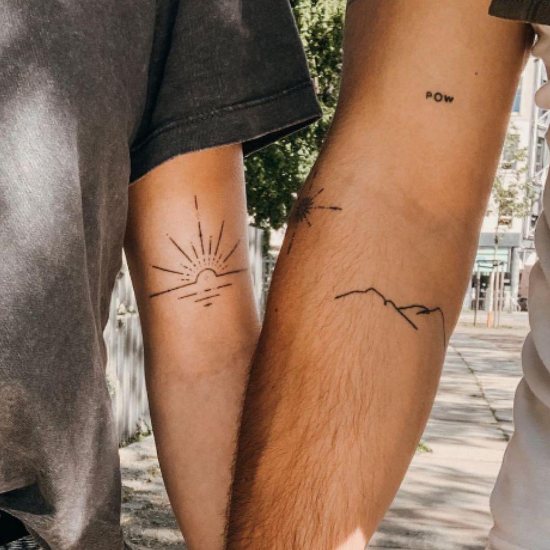 Los tatuajes minimalistas para parejas pueden ser sinónimo de grandes sentimientos, ya que representan la entrada en un universo en el que todo es nuevo, excitante y listo para ser explorado, como el sol ilumina la belleza natural de una cadena montañosa.