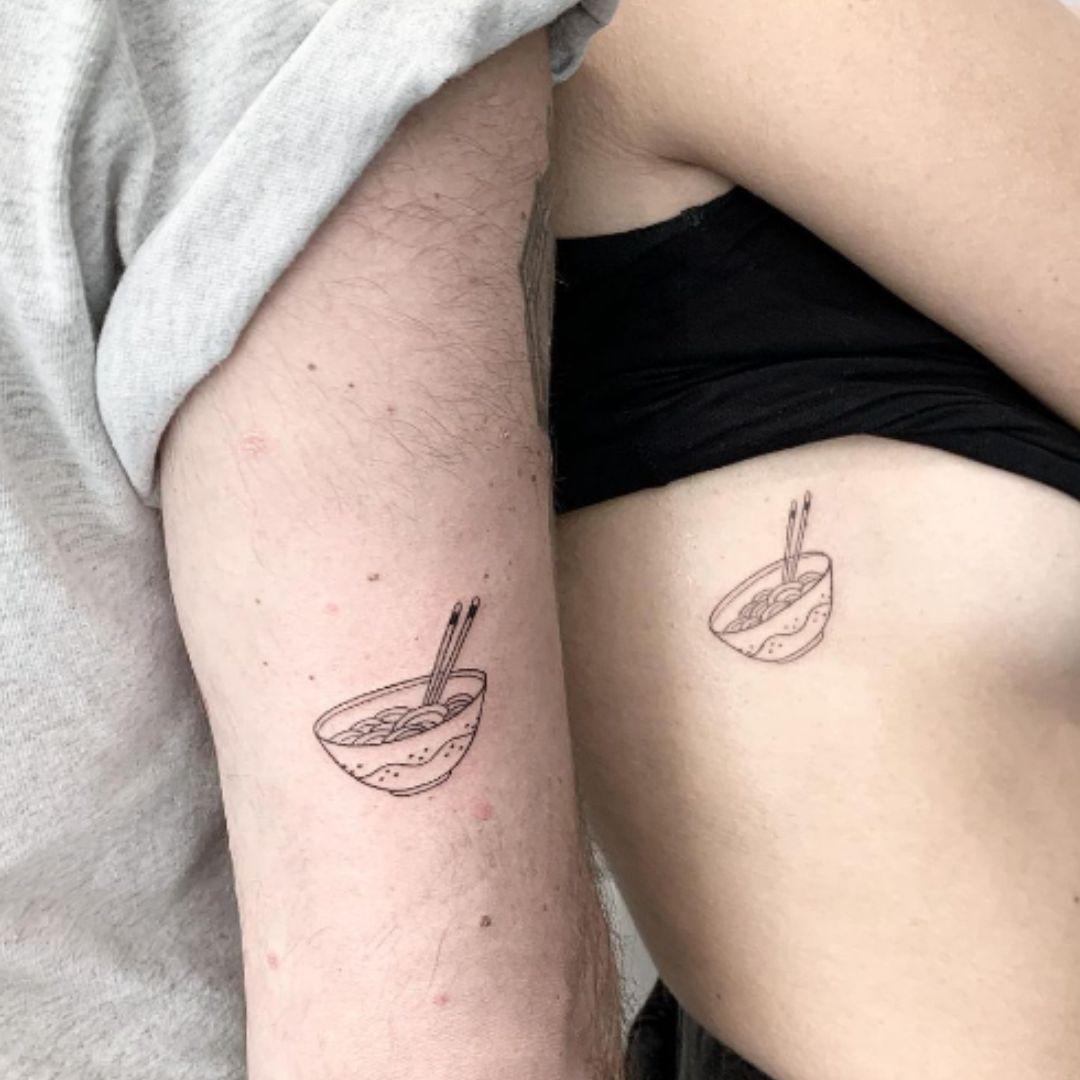 Este tatuaje minimalista, como un recordatorio de la primera comida que compartieron juntos, es un homenaje a su unión y a la memoria de aquel momento especial.