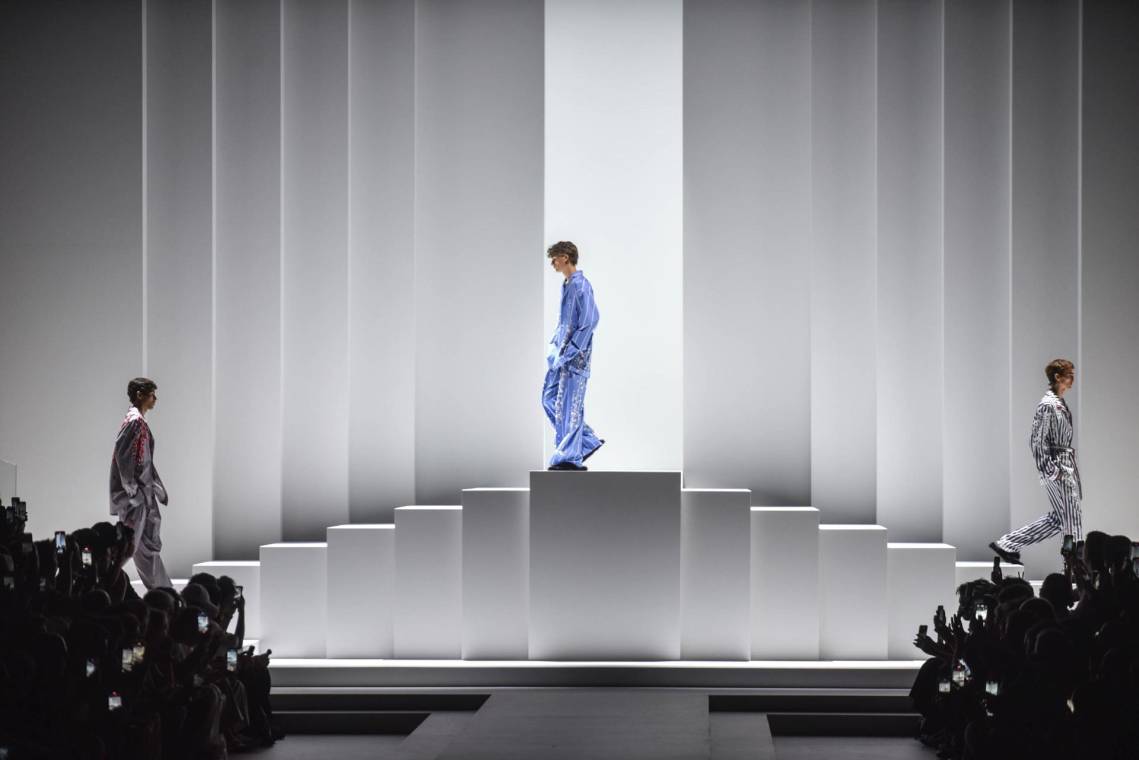 Las pijamas salen de la cama directo a la calle, esa es la premisa de la colección Menswear Spring-Summer 2026 presentada por Dolce&amp;Gabbana en Milán. Versiones casuales y desenfadadas, pero también con cuidados bordados en una versión de noche, vuelven a la pasarela como una pieza insigne de la marca desde los años 90.