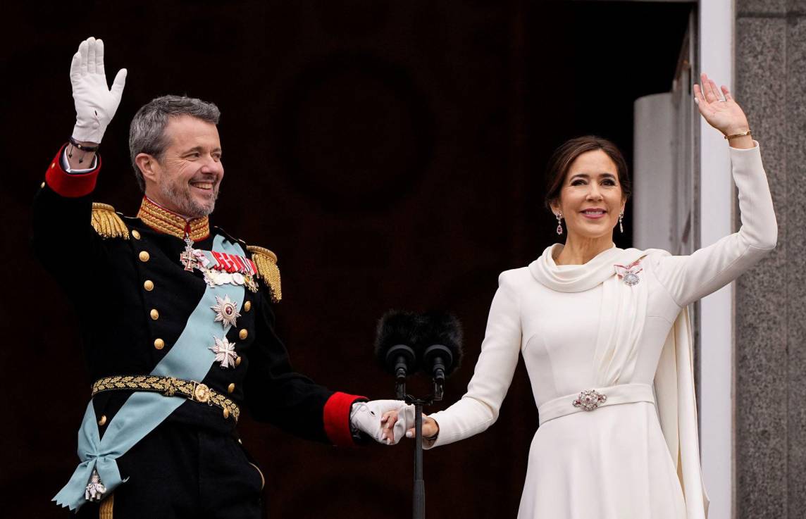 Luego de ser proclamado rey de Dinamarca, Federico X, enfundado en un traje militar, saluda al público desde el balcón del palacio de Christiansborg junto a su esposa Mary, quien eligió un vestido blanco estilo evasé con capa y un set de diamantes y rubíes que data de 1804.