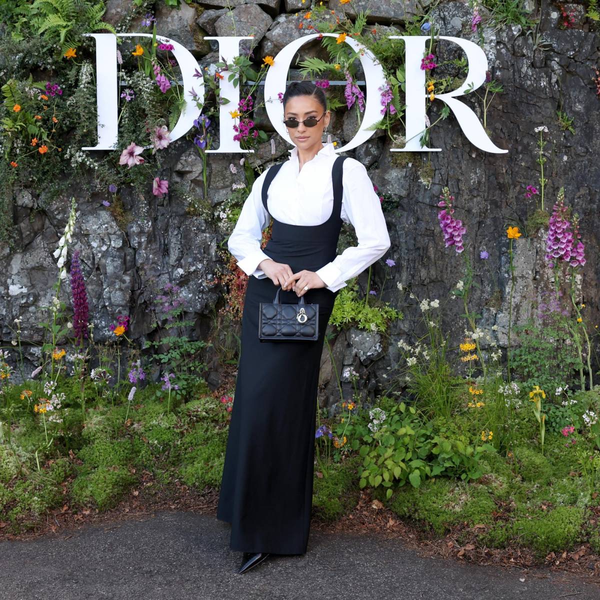 La actriz de Pretty Little Liars, Shay Mitchell, lució un maxi dress negro accesorizando con unos lentes negros y una Mini Dior Book Tote
