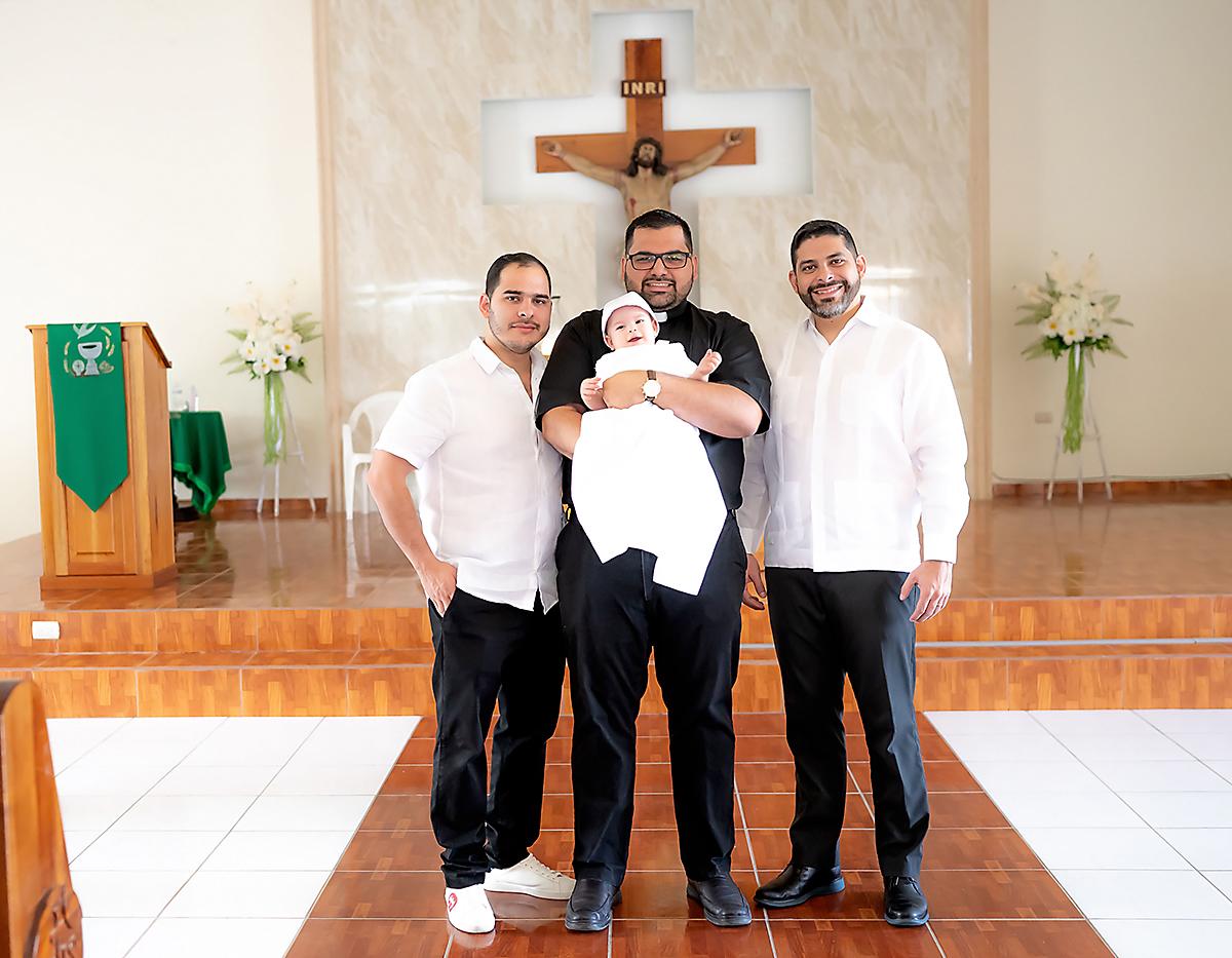 El padrino Jorge Grande con el sacerdote Daniel Fernández, el nuevo cristiano Christian André y su papá Yankel Valladares.