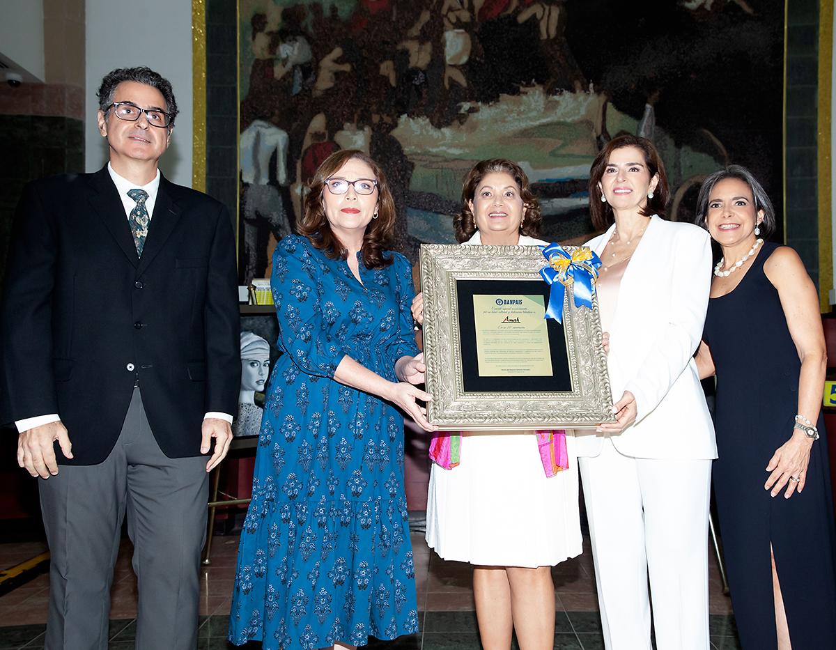 Como reconocimiento especial a AMAH por su dedicación y labor cultural, Banco del País realizó la entrega de una placa conmemorativa en virtud de sus veinte años empoderando a la mujer hondureña a través de las artes plásticas y generando espacios con una proyección significativa para muchos . Gustavo Larach, Nidia Manzanares, Leticia Morales, Suyapa Monterroso y Gabriela Becerril, en la inauguración de XX Edición de la Expoventa “El Arte y la Paz en Honduras”