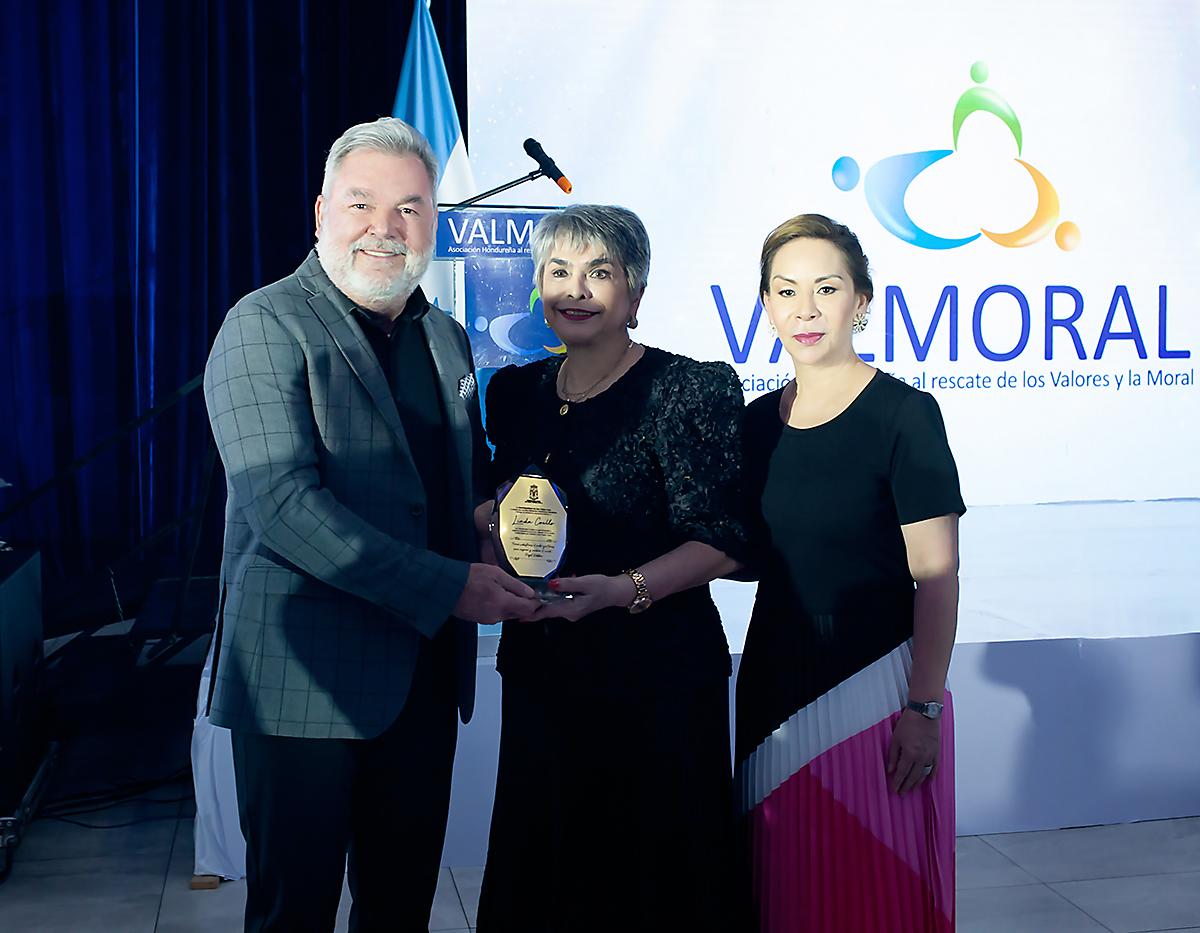 Roberto Contreras, alcalde de la Municipalidad de San Pedro Sula hace entrega de una placa a Linda Coello por su destacada labor social, junto a ella Zoila Santos de Contreras