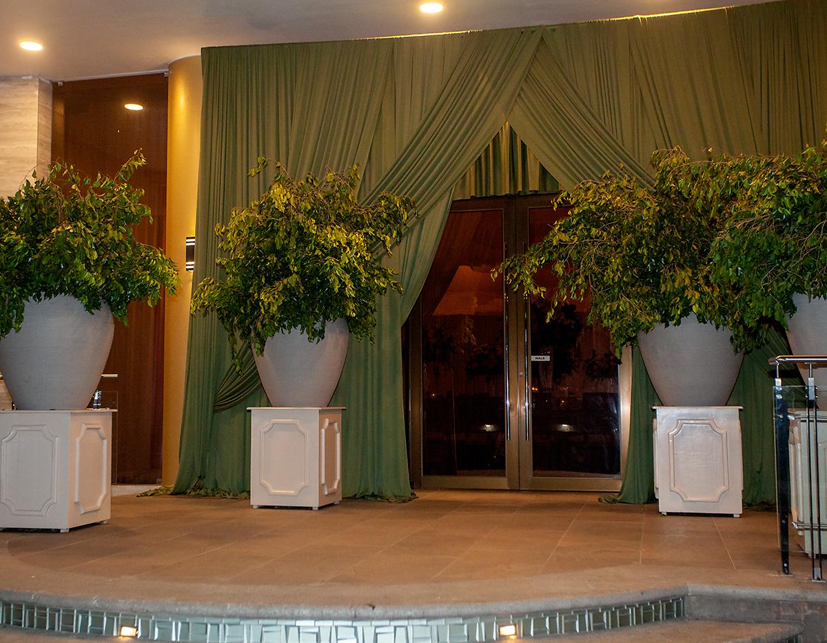 La entrada al salón fue adornada con gigantescos jarrones con follaje.