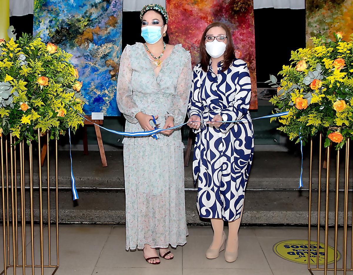 La pintora Nora Buchanan y Nidia Manzanares, gerente corporativo de mercadeo y comunicaciones de Banpais, durante el corte de cinta inaugural.