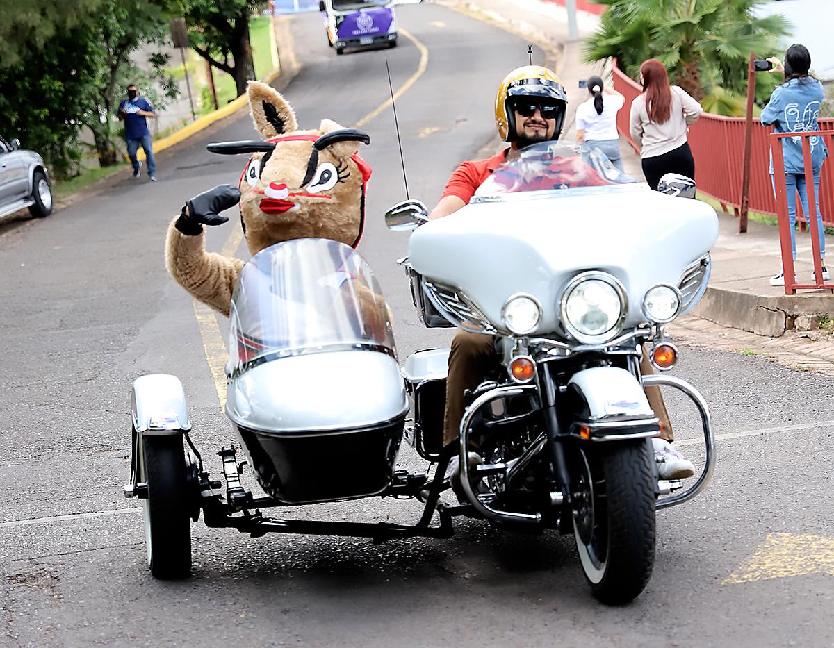 La gacela, mascota de la clase, junto a un motorizado rumbo al gimnasio escolar