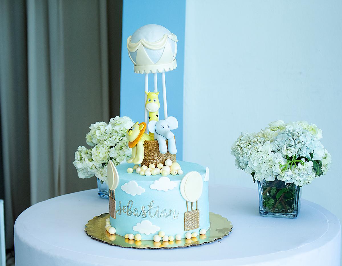 Pastel de fondant adornado con figuras de globos y animales.