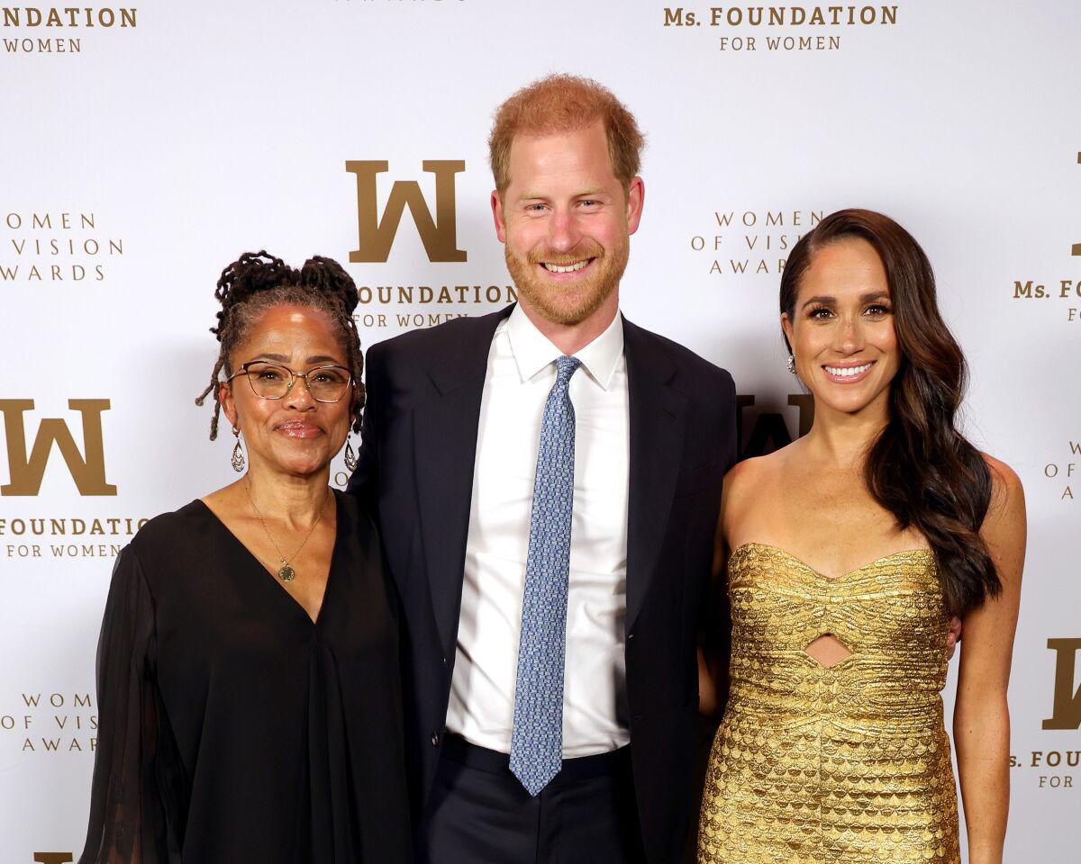 Meghan con su esposo Harry y su madre Doria