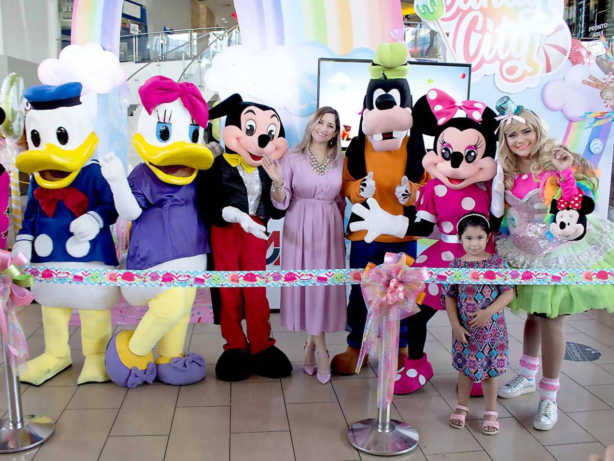 Gisselle Marín, coordinadora de mercadeo de City Mall, en compañía de los personajes de Disney Friends durante la inauguración del parque temático “Candy City”.