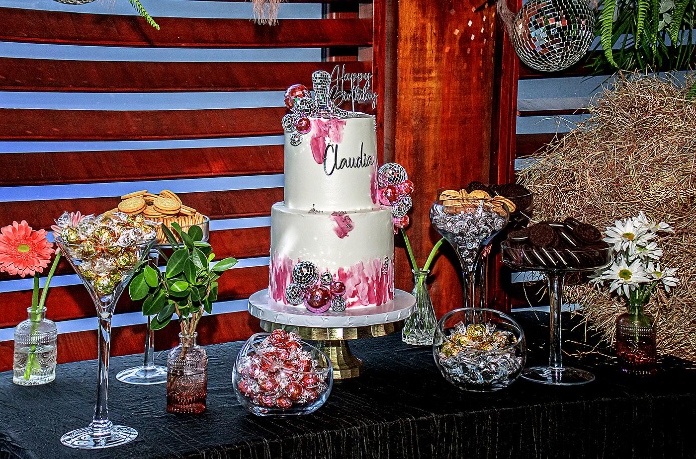 Pastel de cumpleaños con detalles de figuras de botas, flores y esferas, elaborado por Annie Bueso.