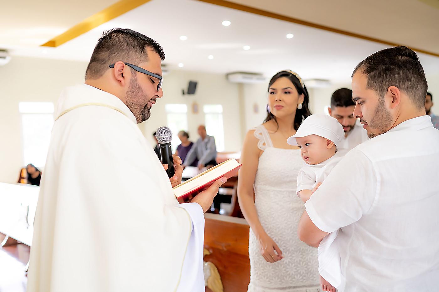 El sacerdote Daniel Fernández, con los padrinos del bebé Christian André Valladares, durante el bautizo