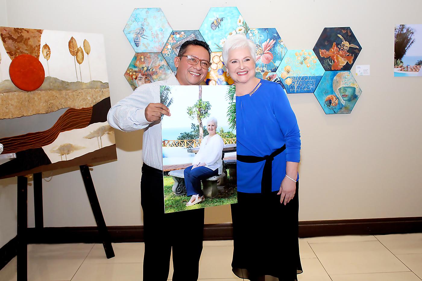 Agustín Ortega hace entrega de un lienzo con retrato de la pintora Margarita Rodríguez.