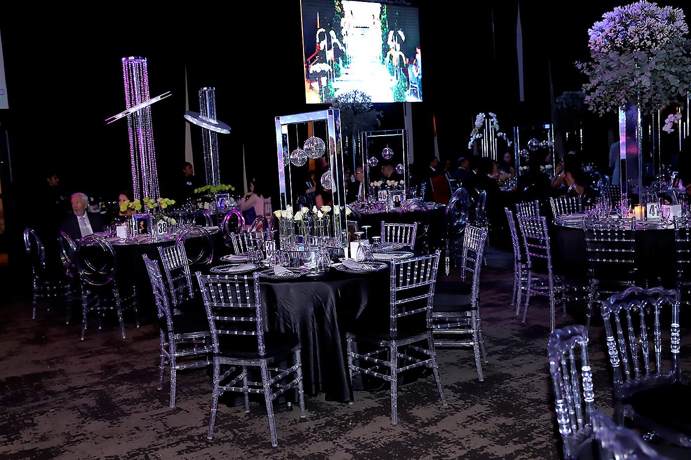 Mesas vestidas de negro rodeadas de ghost chairs y tiffany recibieron a los invitados mientras aguardaban el ingreso de los seniors al Centro de Convenciones del Honduras Maya