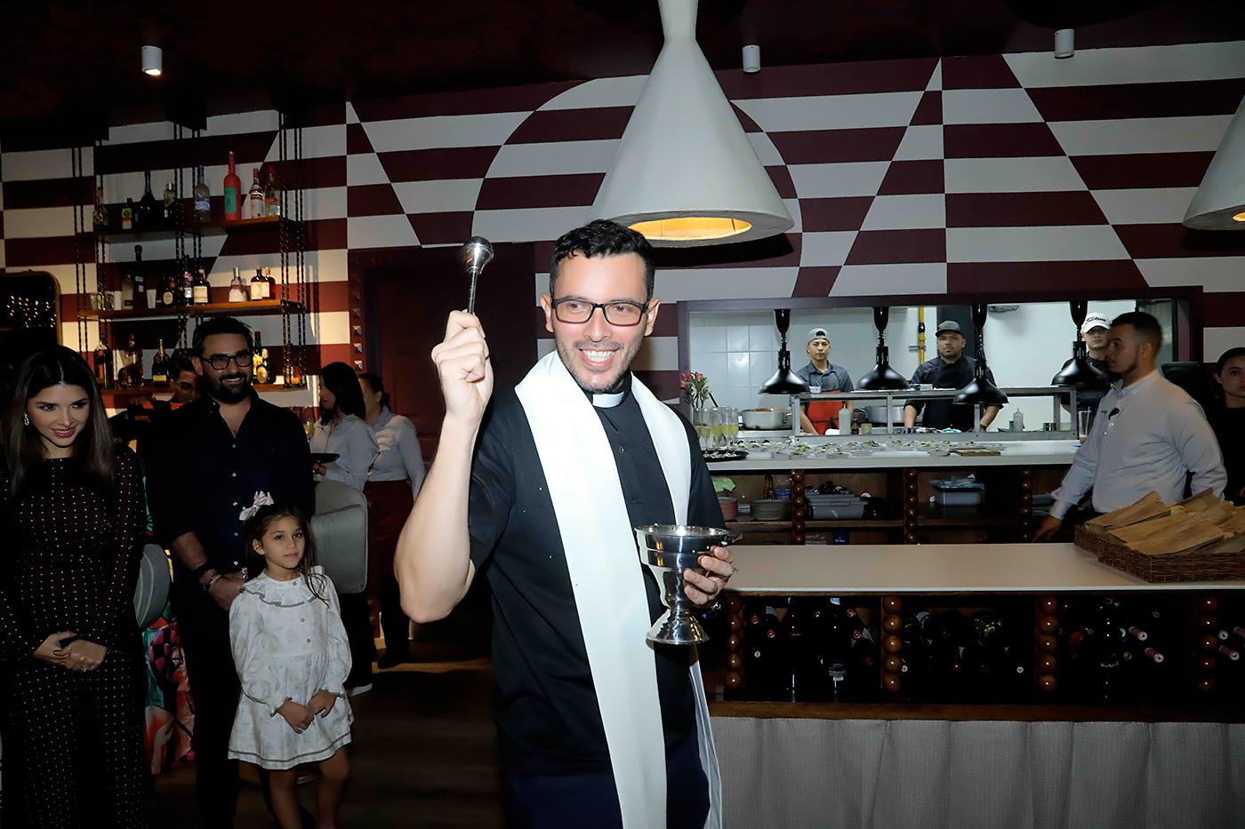 El padre Julián Quimbayo de la parroquia La Santa Cruz, durante la bendición del nuevo local de Hasta La Pasta.