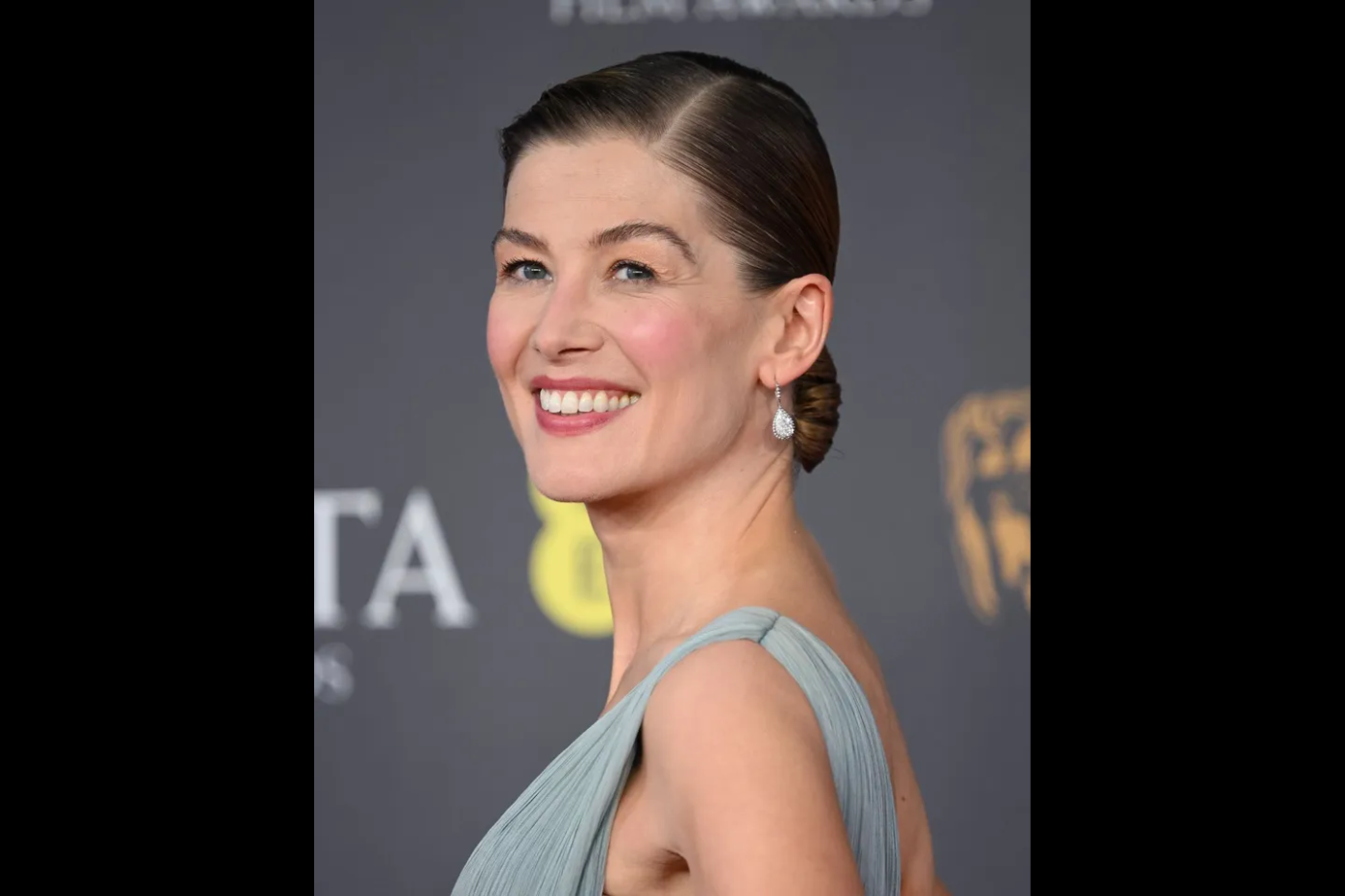 Los peinados recogidos de inspiración vintage también fueron una gran tendencia en la alfombra roja de los BAFTA este año, y el moño bajo y la raya lateral afilada de Rosamund Pike encantó.