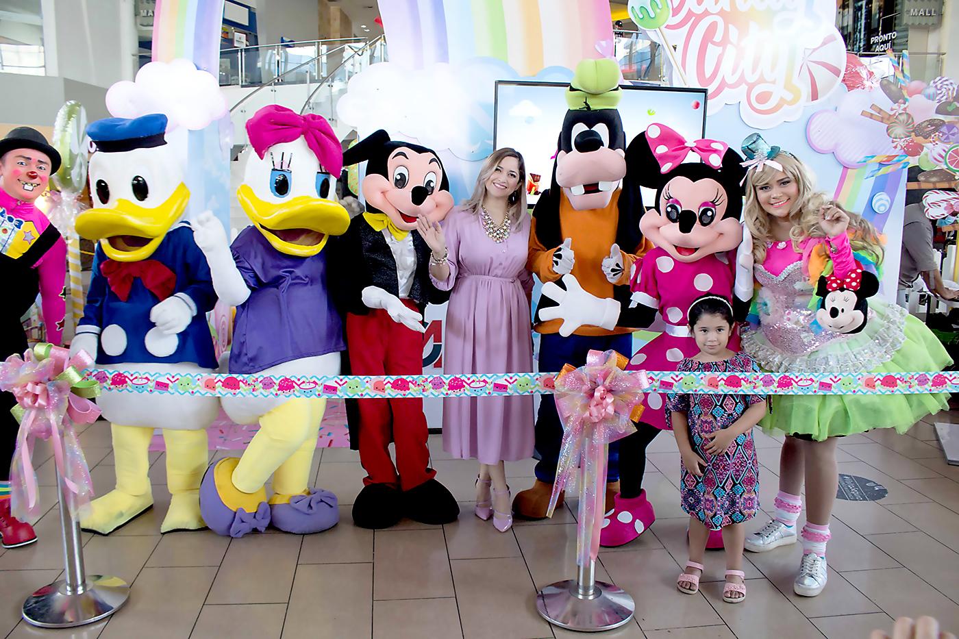 Gisselle Marín, coordinadora de mercadeo de City Mall en compañía de los personajes de Disney Friends, durante la inauguración del parque temático “ Candy City”
