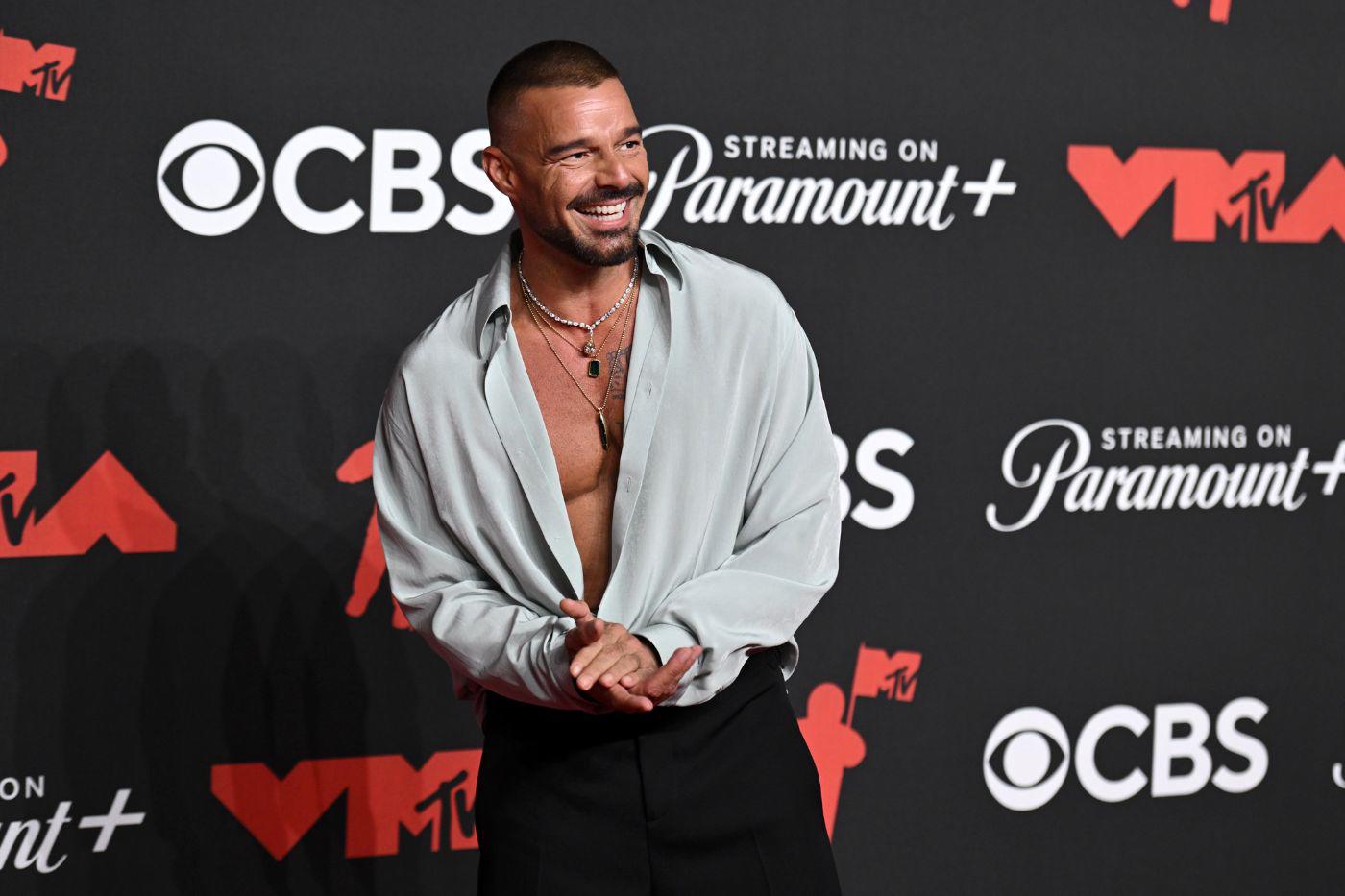 Ricky Martin asombró con una camisa <i>oversized </i>con un efecto satinado que llevó abierta en conjunto con unos pantalones negros anchos y varios collares brillantes. 