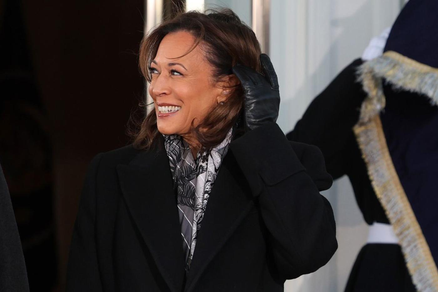 Kamala Harris usa un un look sobrio coronado por un abrigo negro, con zapatos de tacón bajo y un pañuelo estampado al cuello como único accesorio. 