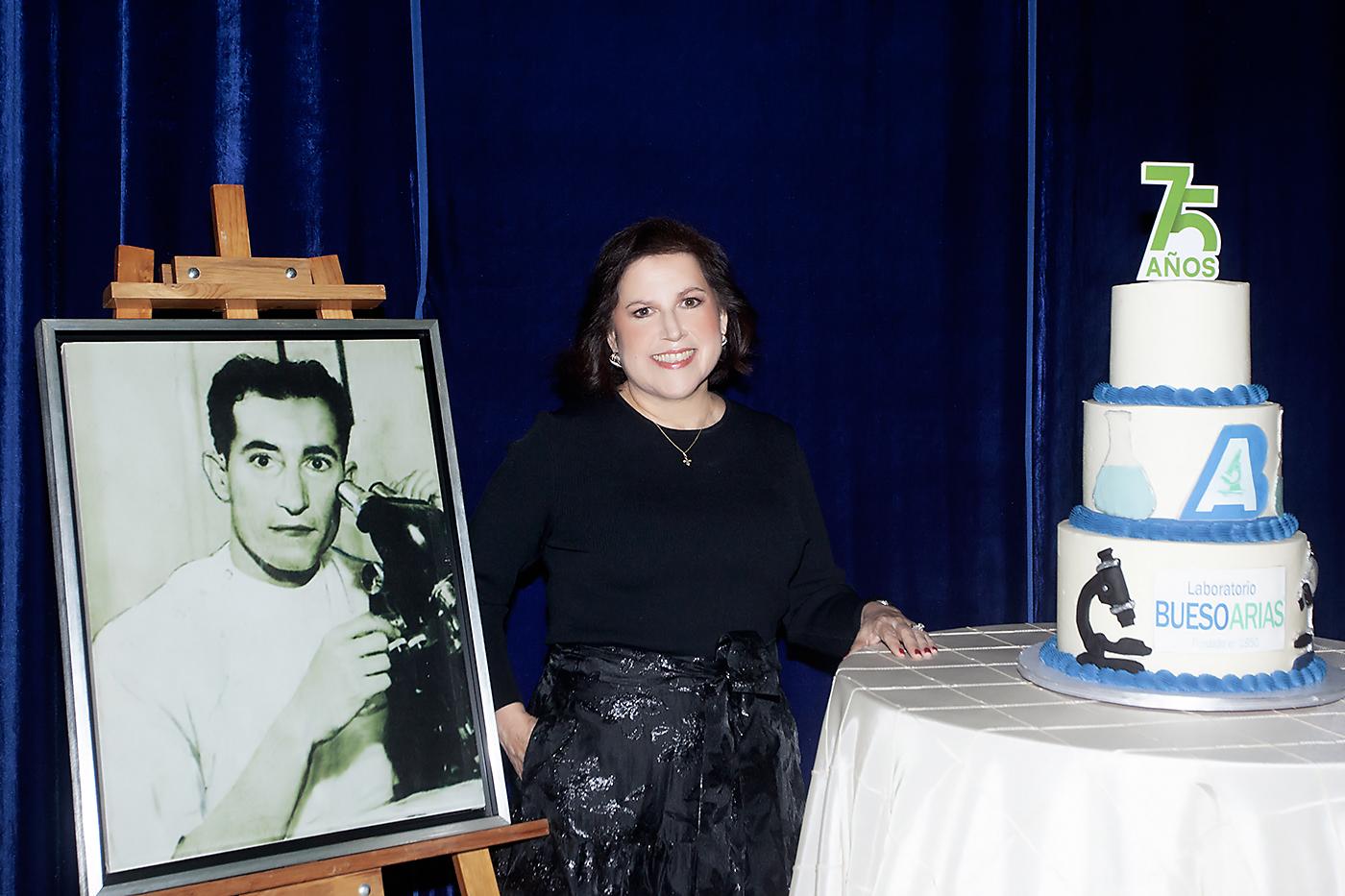 Ana Clemencia, junto a la foto de su padre Abraham Bueso Hernández y el pastel de cumpleaños.