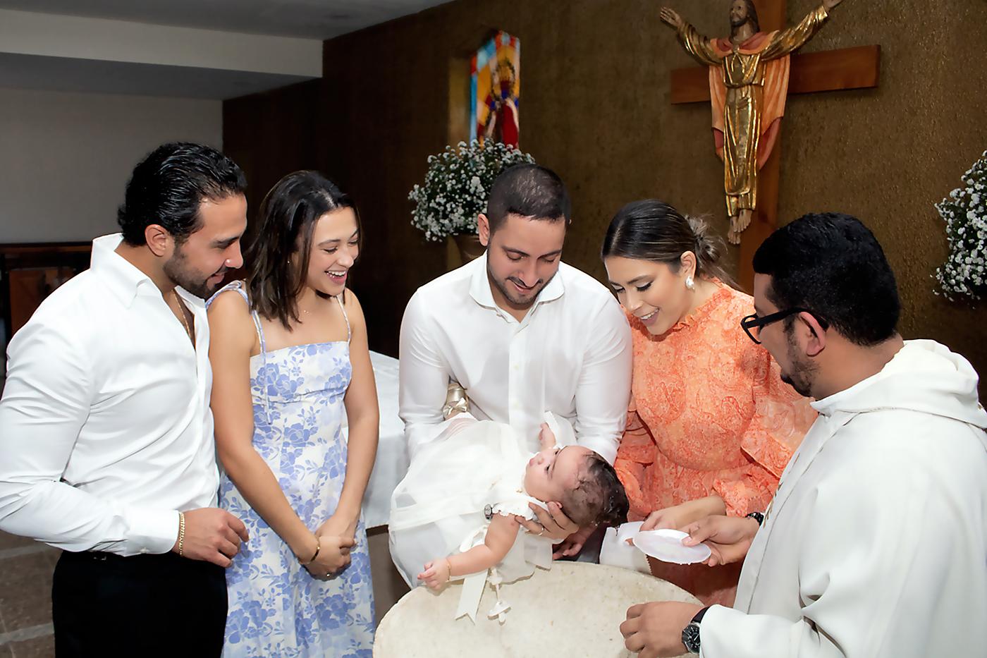 Ivanna Suazo Marsan al momento de recibir las aguas bautismales rodeada de sus padres y padrinos
