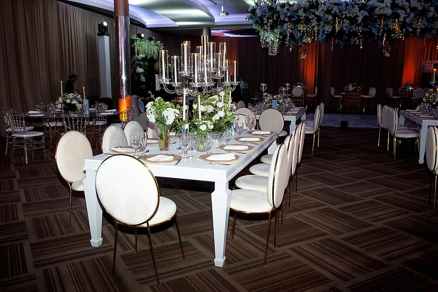 Para la ocasión, eligieron mesas rectangulares combinadas con sillas Luis XV, adornadas con candelabros estilo Chandelier y pequeños arreglos.