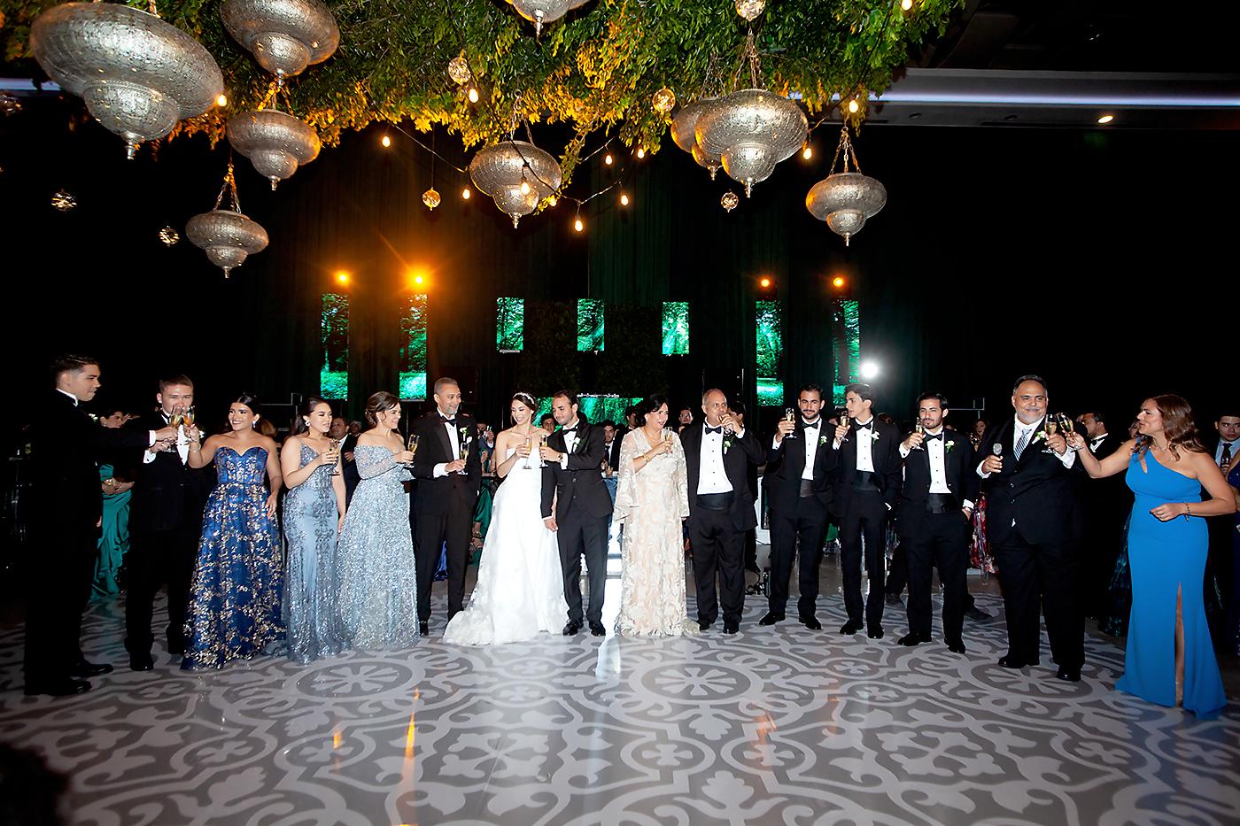 Los recién casados Faiz Andonie y Stephanie Nicole Dox elevan sus copas junto a sus familiares durante el brindis en su honor