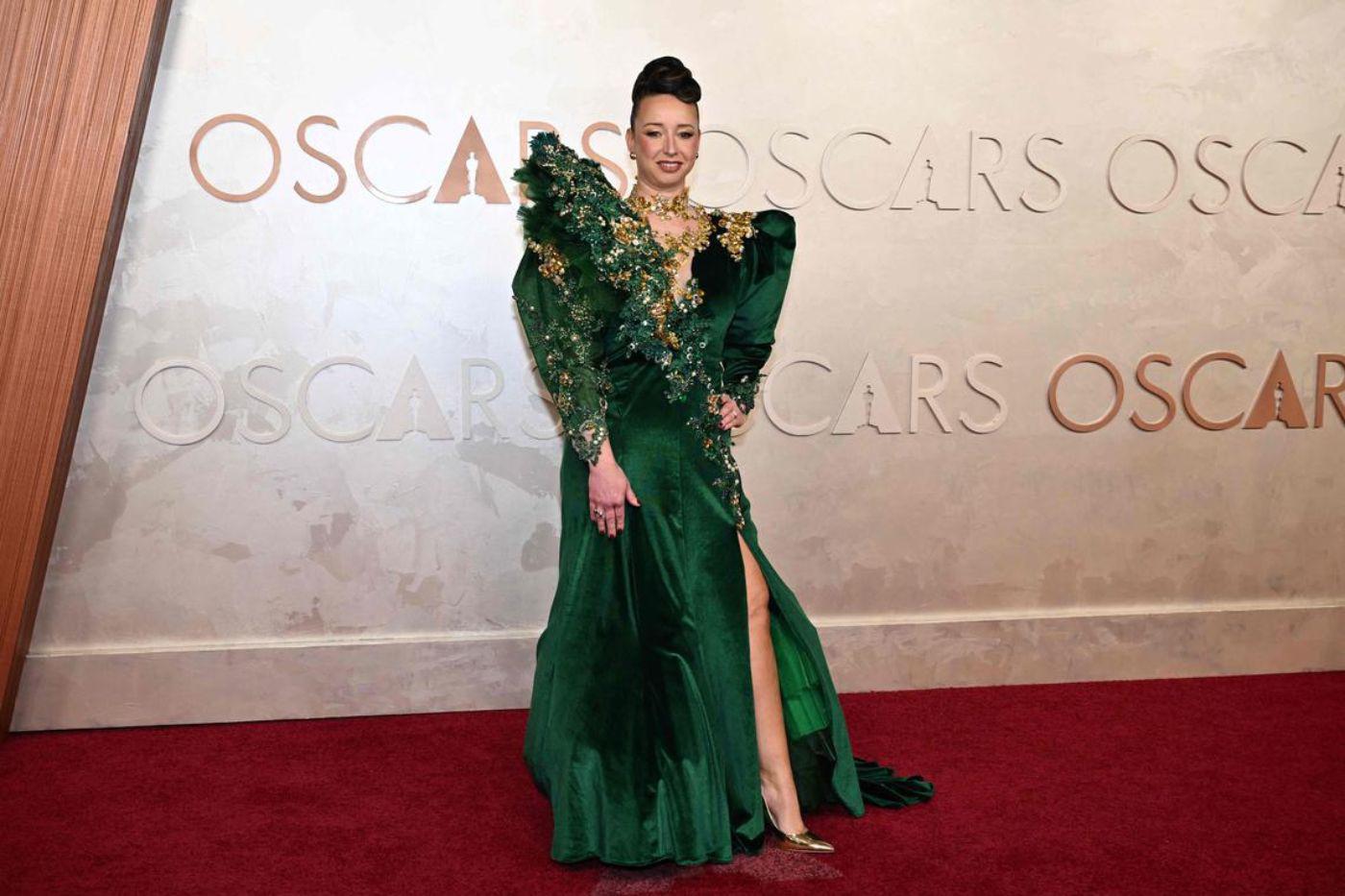 <b>Laura Blount en Hellavagirl</b>La maquilladora nominada por su trabajo en ‘Wicked’ eligió un vestido verde esmeralda de Hellavagirl con mangas abullonadas y detalles dorados. La elección fue considerada excesiva y poco favorecedora.