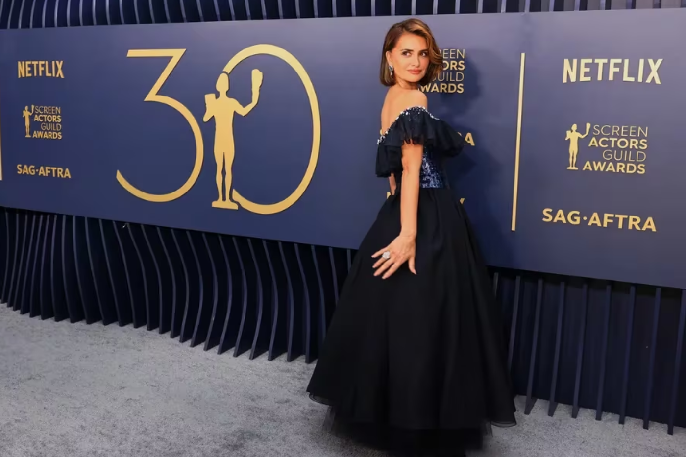 Penélope Cruz ha vuelto a confiar en su firma de cabecera, Chanel. En esta ocasión, usó un diseño con cuerpo de pedrería, escote bardot y volante, en el que se combinan los tonos azul marino y negro.