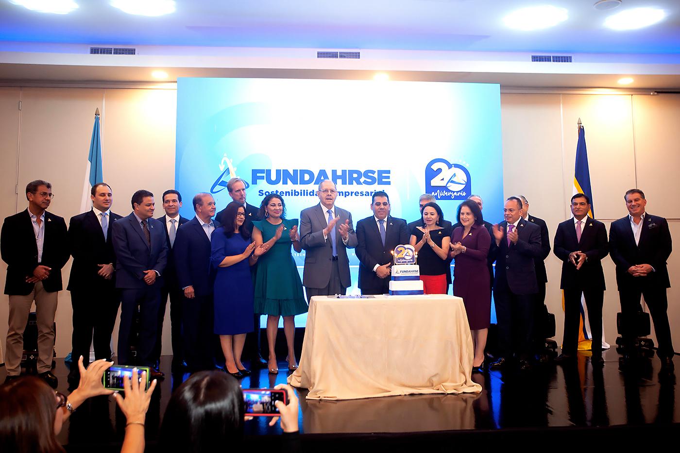 La junta directiva y colaboradores al momento de partir el pastel.