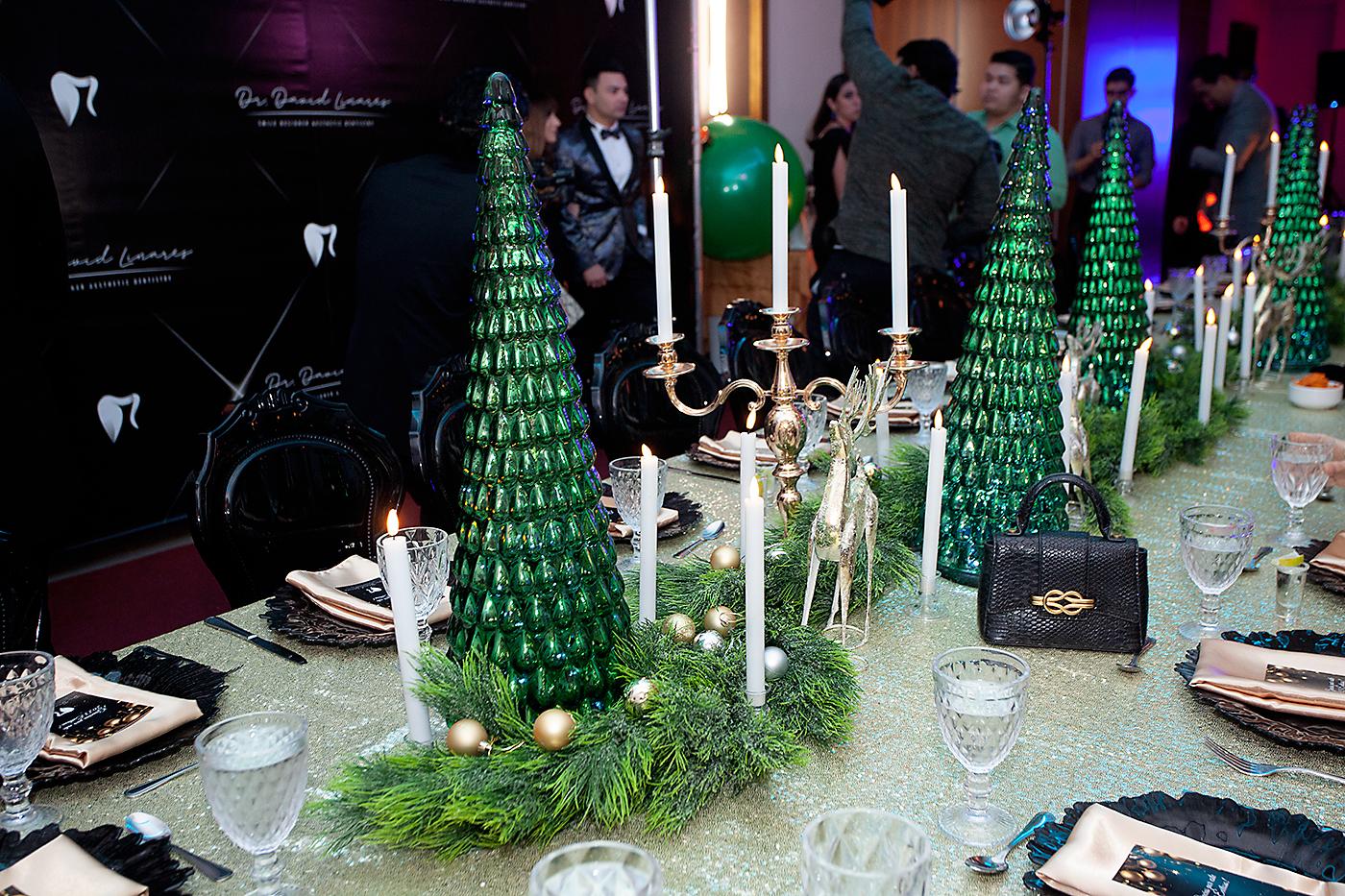 Una mesa rectangular estilo imperial adornada con una guirnalda de ciprés, esferas doradas, figuras de árboles, renos y candelabros fue instalada en el salón Emperador VI.