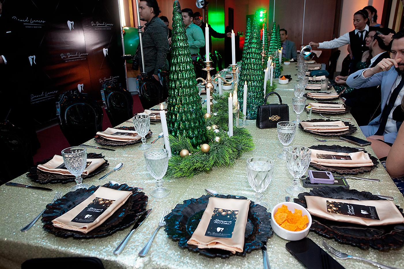 Una mesa rectangular estilo imperial adornada con una guirnalda de ciprés, esferas doradas, figuras de árboles, renos y candelabros fue instalada en el salón Emperador VI.