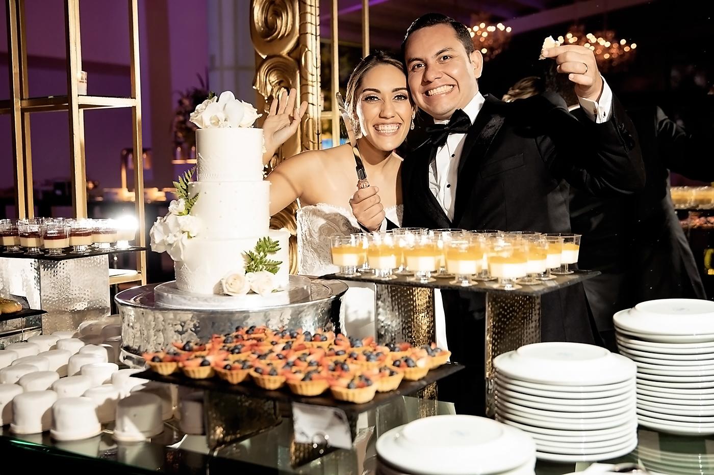 Los recién casados posan frente al wedding cake